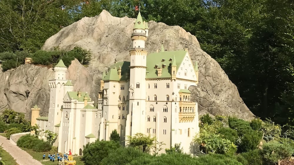 Une maquette d’un château doté d’un toit végétalisé, entouré d’arbres et bordé d’un sentier.