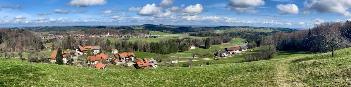 Blick über Frasdorf im Chiemgau mit blauem Himmel und kleinen weißen Wolken, Bayern, Deutschland