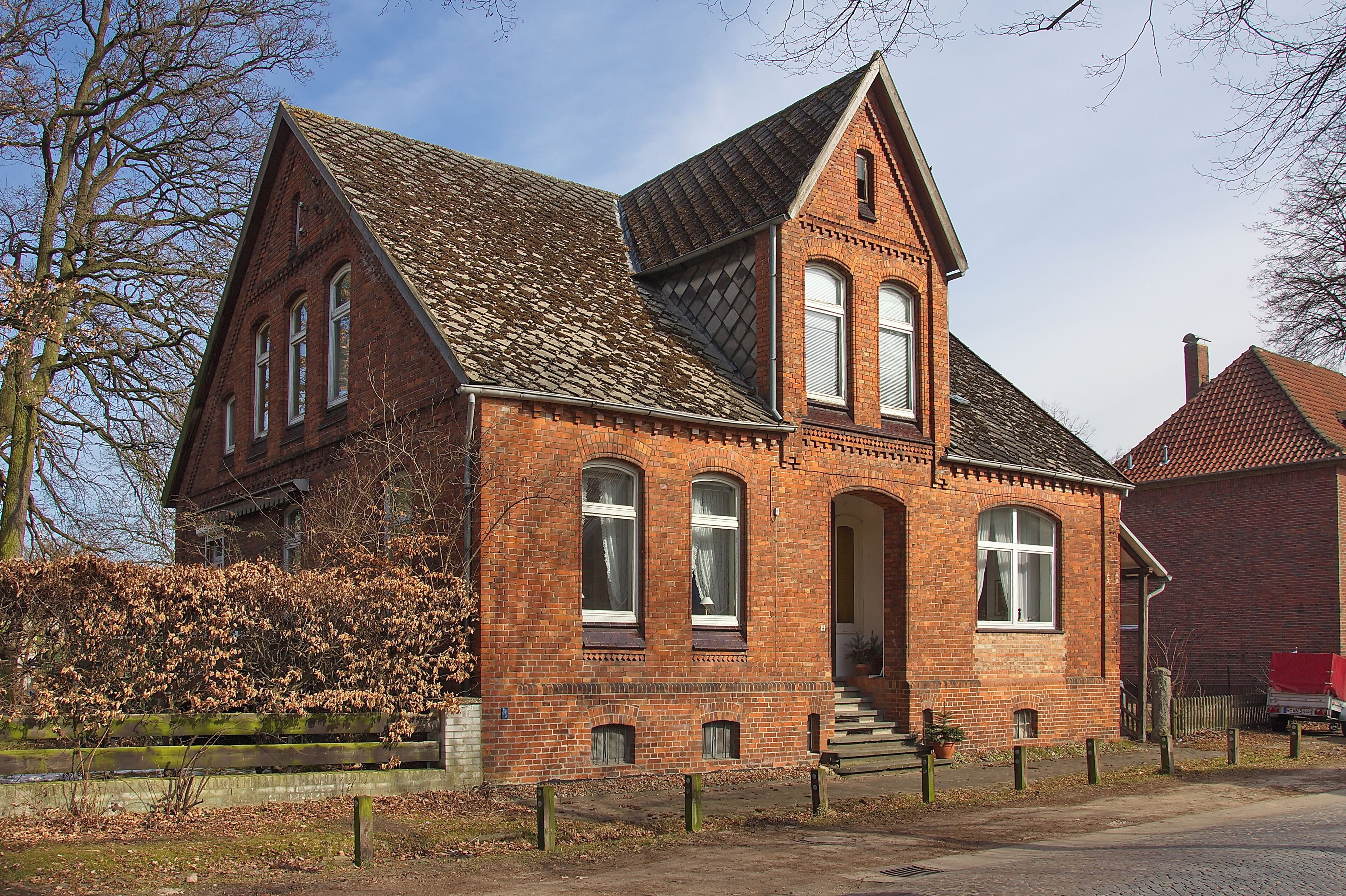 A red brick building with a steeply pitched roof and arched windows.