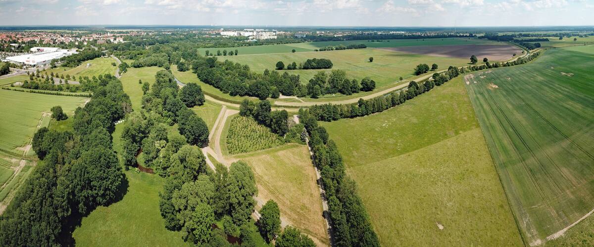 An aerial view of a rural landscape with fields, trees, and a large building complex.