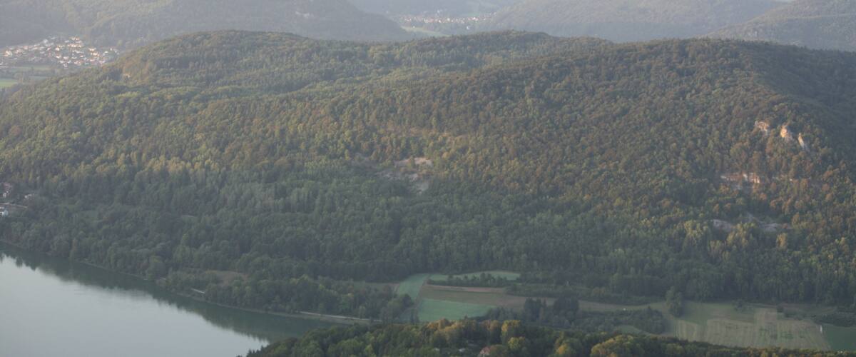 A mountainous landscape with a lake and scattered buildings.