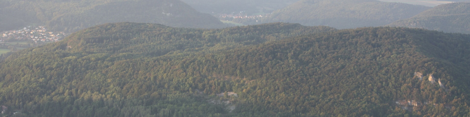 A mountainous landscape with a lake and scattered buildings.