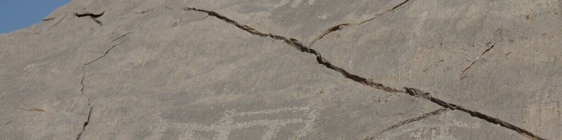 If you continue through the village of Qadah, you will find yourself on a road through farmland. It is very green and pretty. Continue on the road up the wadi (dry riverbed) until you are almost at the end of the road - you end up in Tawi village and there is a wall of mountains in front of you. On the left hand side of the road, just before a large white house (from memory after a white house too), there are ancient petroglyphs carved into the rocks. There is a fairly open space with a tumble of rocks and some are on these and some on the rock face behind or next to them...