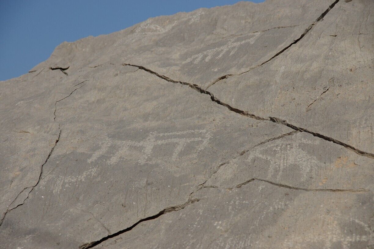 A large rock with visible cracks and a carved face.