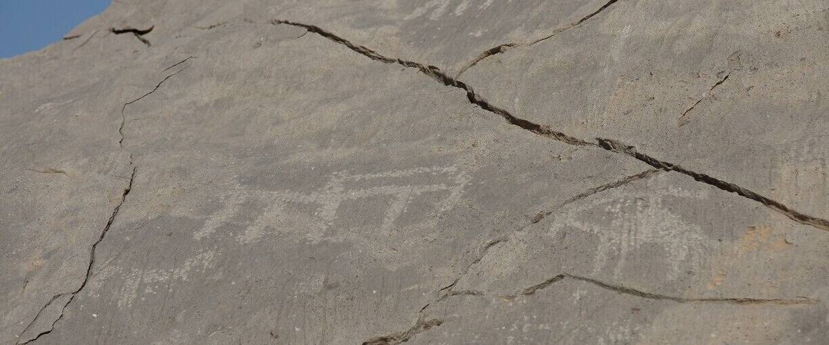 A large rock with visible cracks and a carved face.