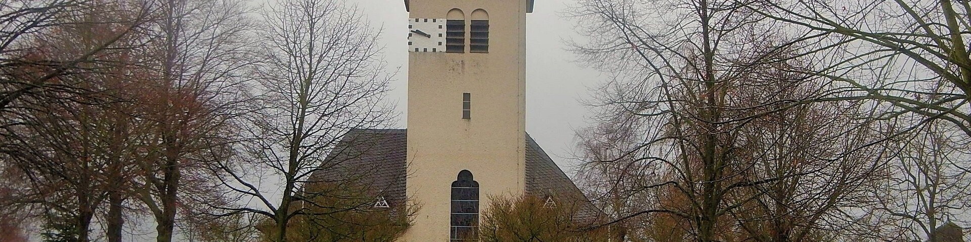 A church with a tall tower and a clock.