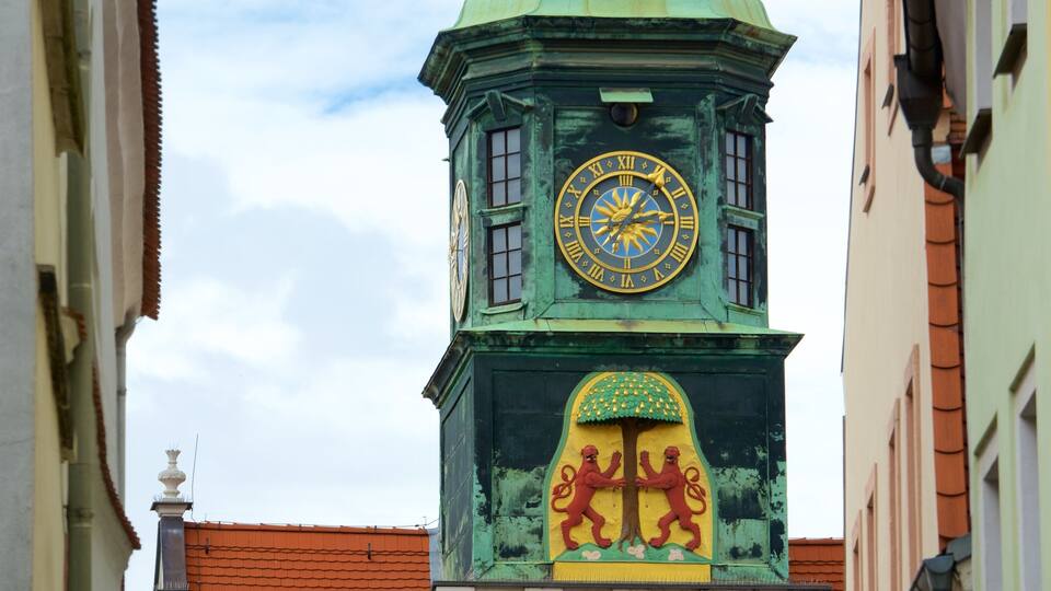 A clock tower with a lion emblem and a large clock face.