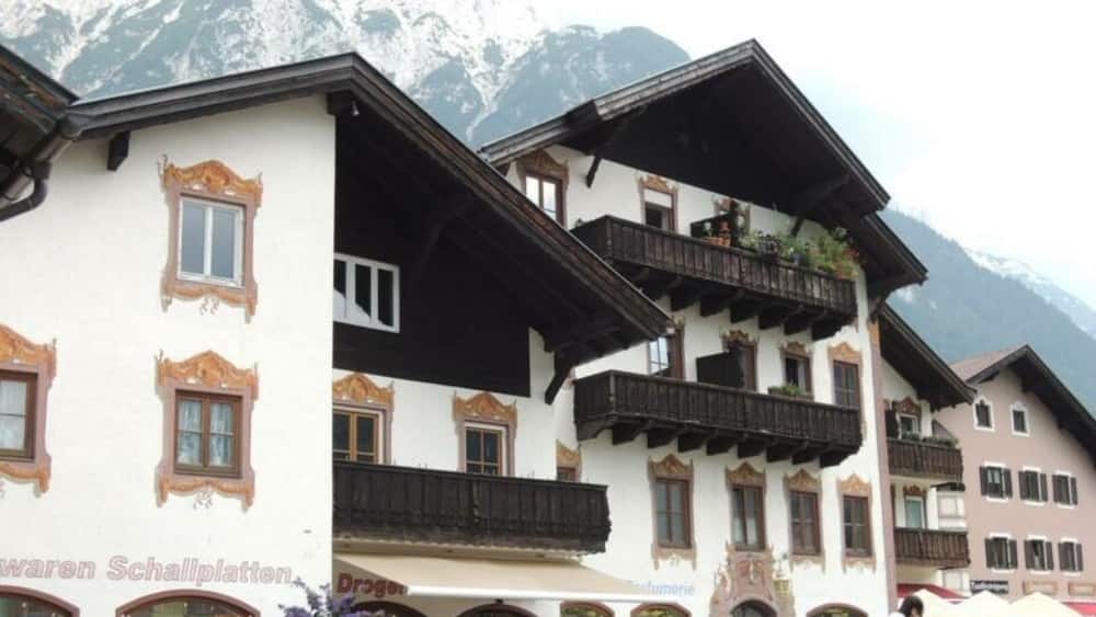 Ein traditionelles Gebäude in den Alpen mit Holzbalkonen und einer Bergkulisse.