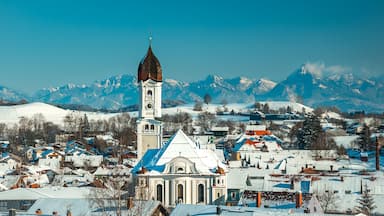 A snow-covered town with a prominent church and mountains in the background.