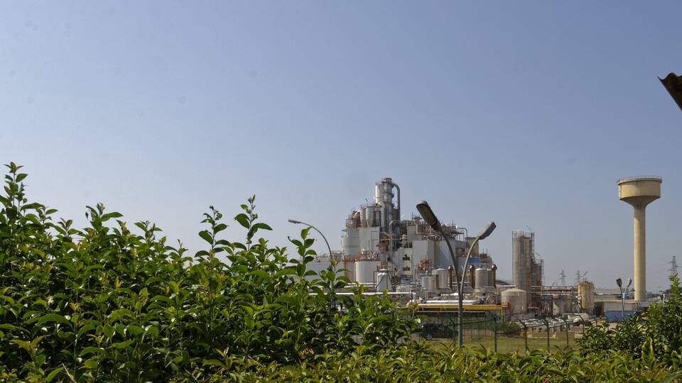An industrial facility with large structures and a water tower.