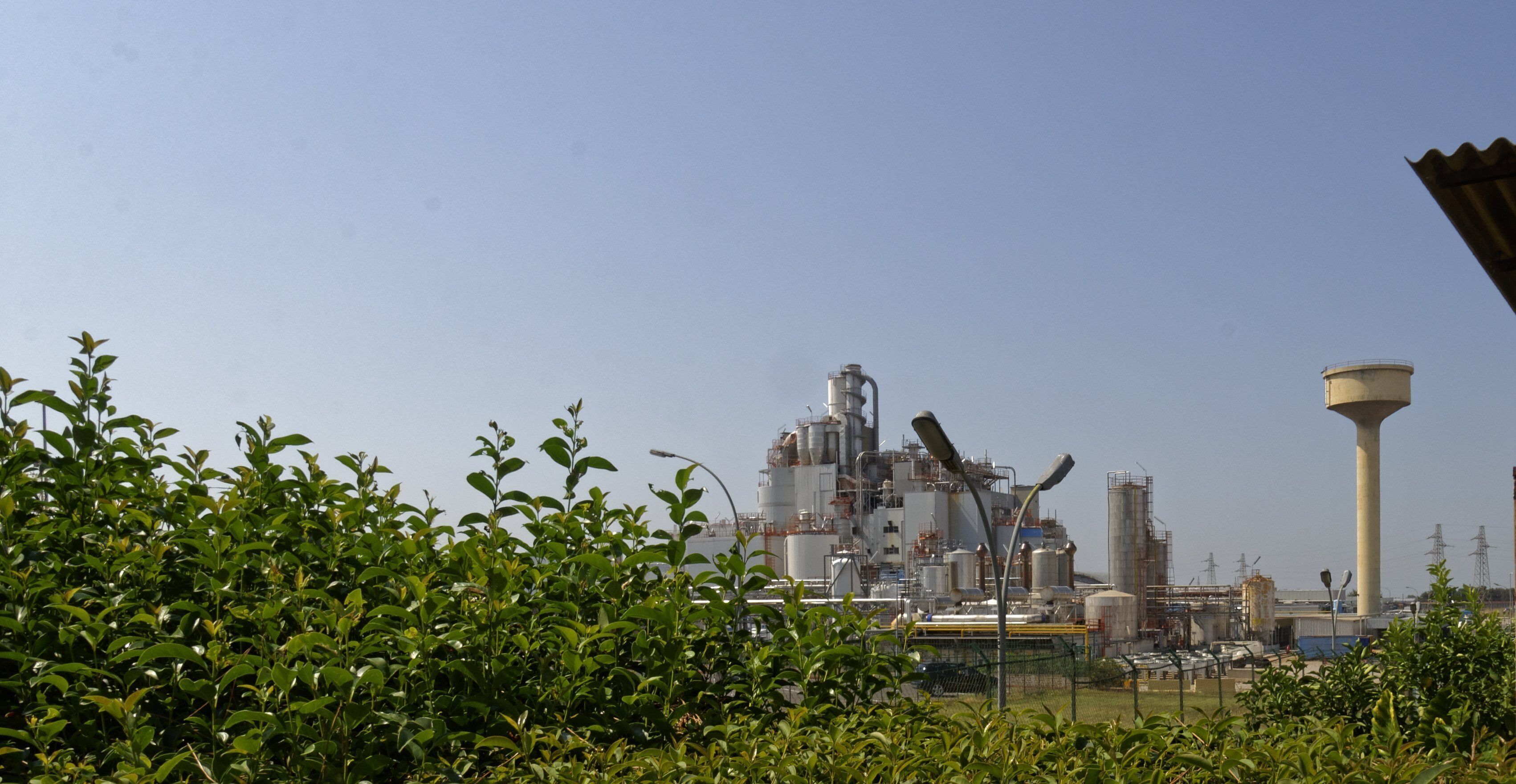An industrial facility with large structures and a water tower.