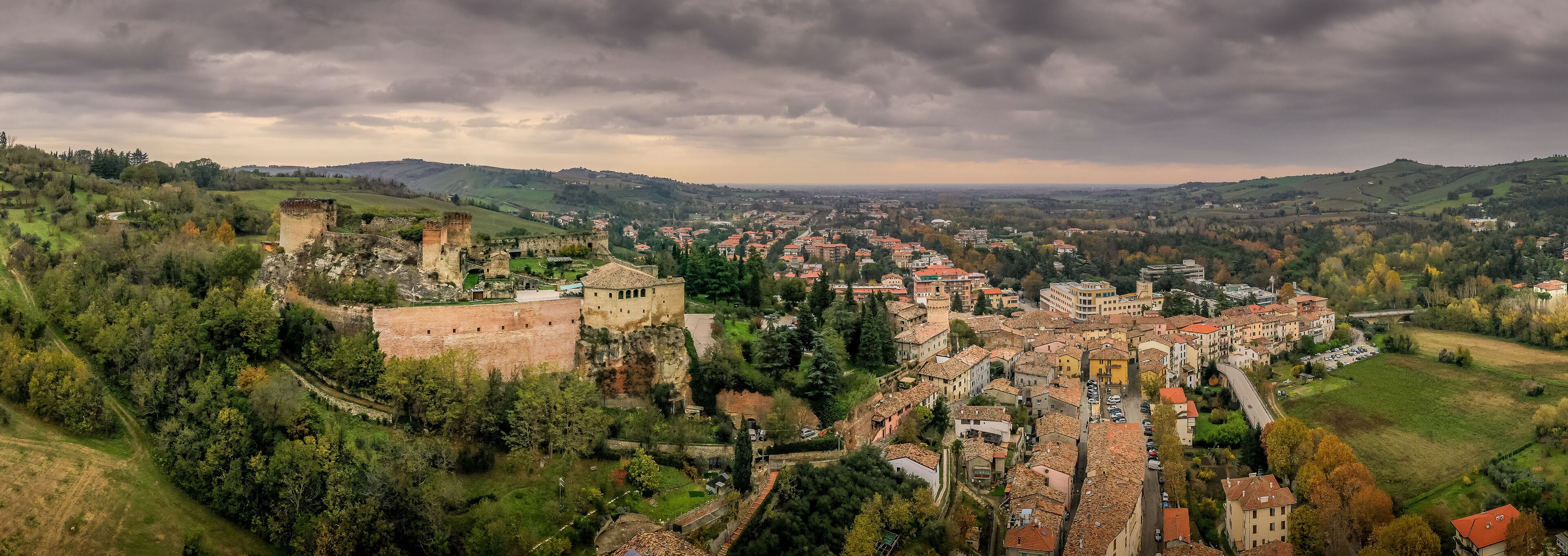 A historic town with a prominent castle, rolling hills, and a mix of traditional and modern architecture.