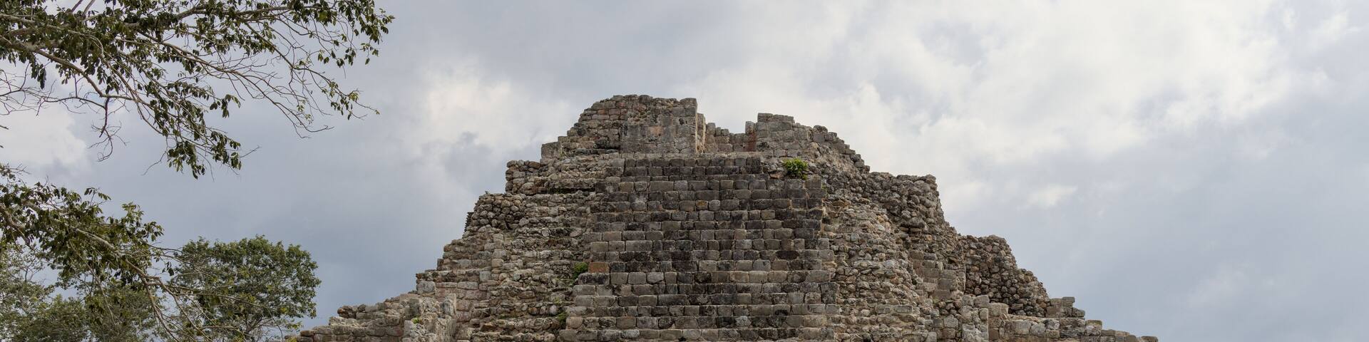 woman standing in front of ancient mayan pyramid ruins in the maya city of oxkintok in yucatan mexico (travel tourism photo blog adventure destination history tour getaway) steps historic monument