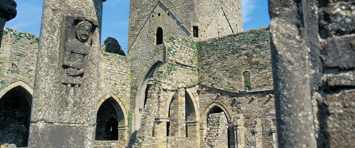 An ancient stone structure with a large tower and arched doorways.