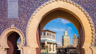 Un edificio histórico con elaborados trabajos en azulejos azules y blancos, un gran arco y un cielo azul despejado.