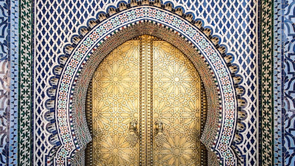 A detailed, ornate door with geometric patterns and a decorative arch.