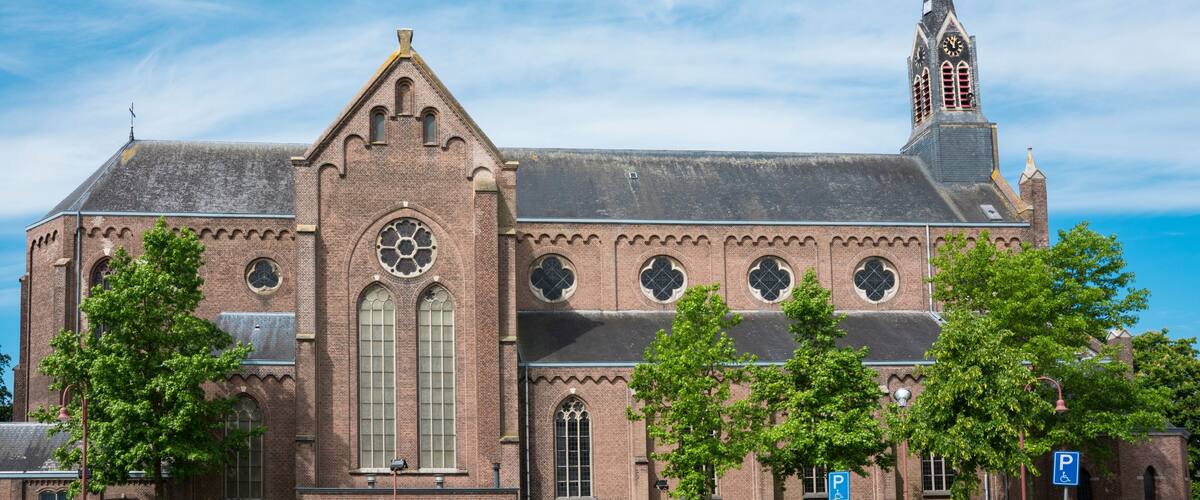 A historic church with a prominent steeple and a large circular window.