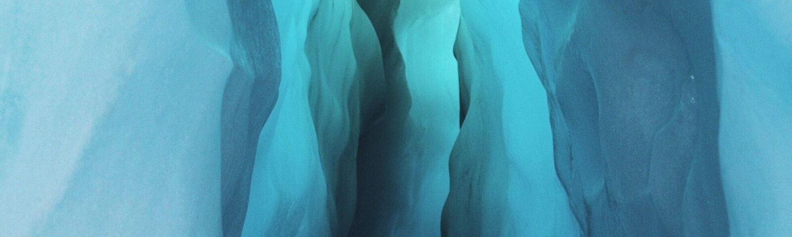 Una cueva de hielo con un estrecho pasaje y una fuente de luz al final.