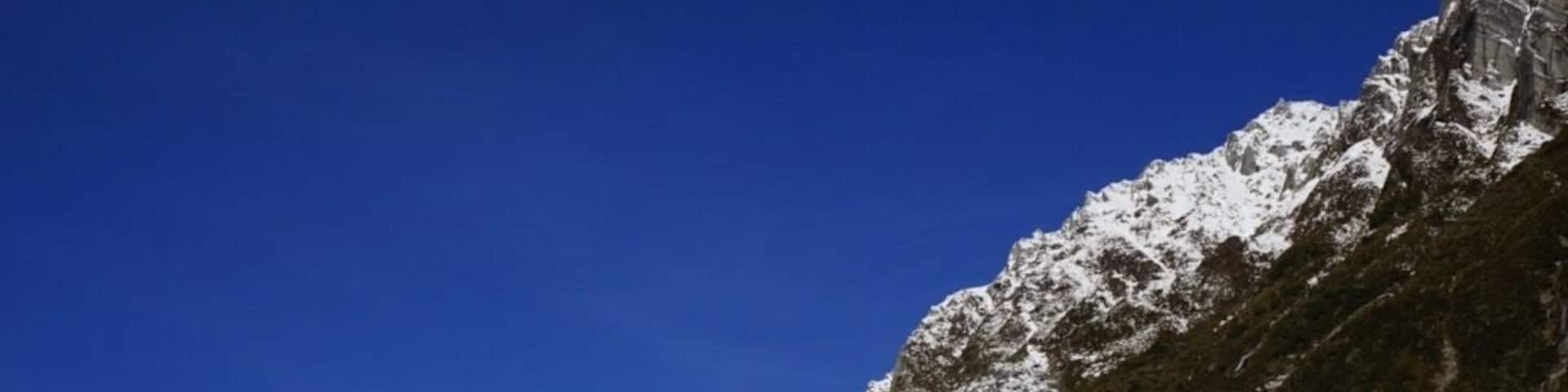 A group of people hiking on a snow-covered glacier with a clear blue sky.
