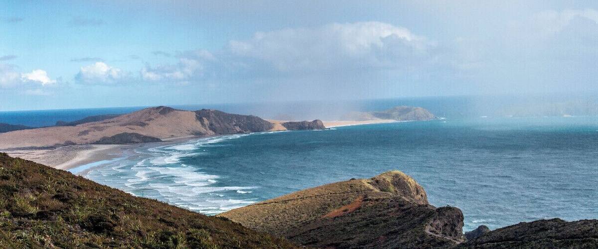 Incoming rain on Te Werahi Beach, Cape Maria van Diemen and Motuopao Island. This view is from New Zealand's most northern point, Cape Reinga. You can walk this beach as part of the Te Araroa trail - a walkway that stems from the most northern point to the most southern point of New Zealand.