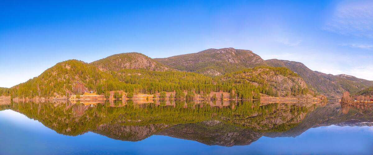 A calm lake reflecting mountains and trees.