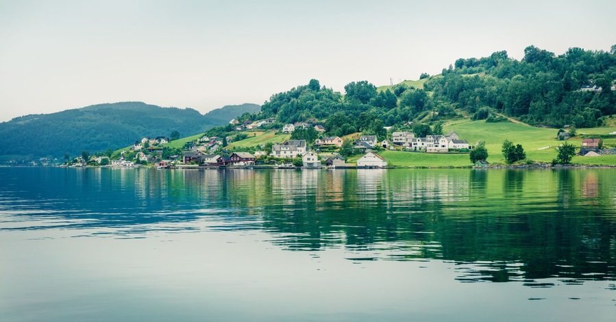 Misty summer view of Oystese village, Hamlagro region, Norvay, Europe. Lovely morning panorama of Hardangerfjord, North Sea. Traveling concept background. Instagram filter toned.