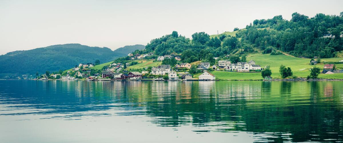 A lakeside village with houses on a hillside.