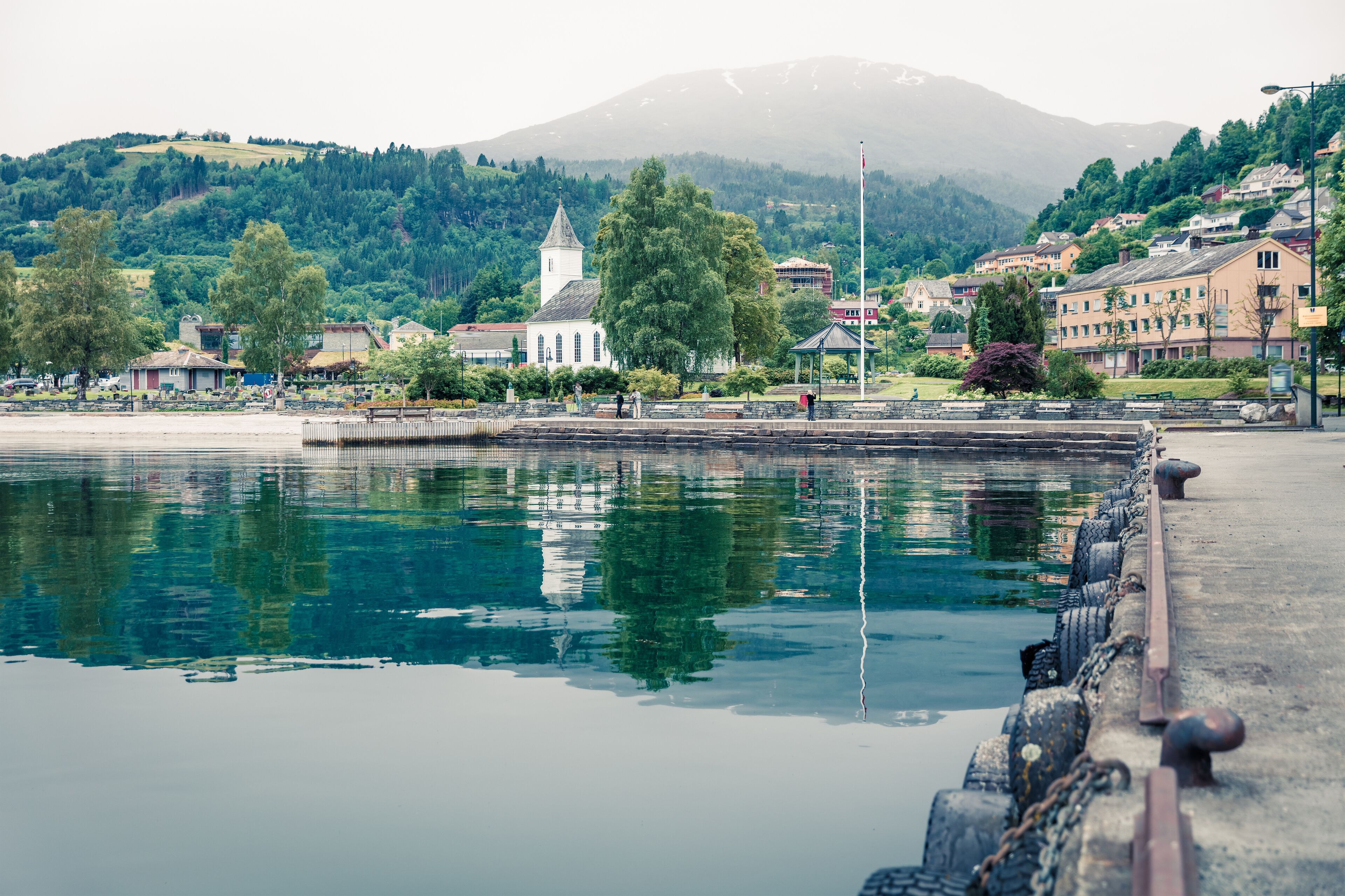 Misty summer view of Oystese village, Hamlagro region, Norvay, Europe. Stunning morning scene of Hardangerfjord, North Sea. Traveling concept background. Instagram filter toned.
