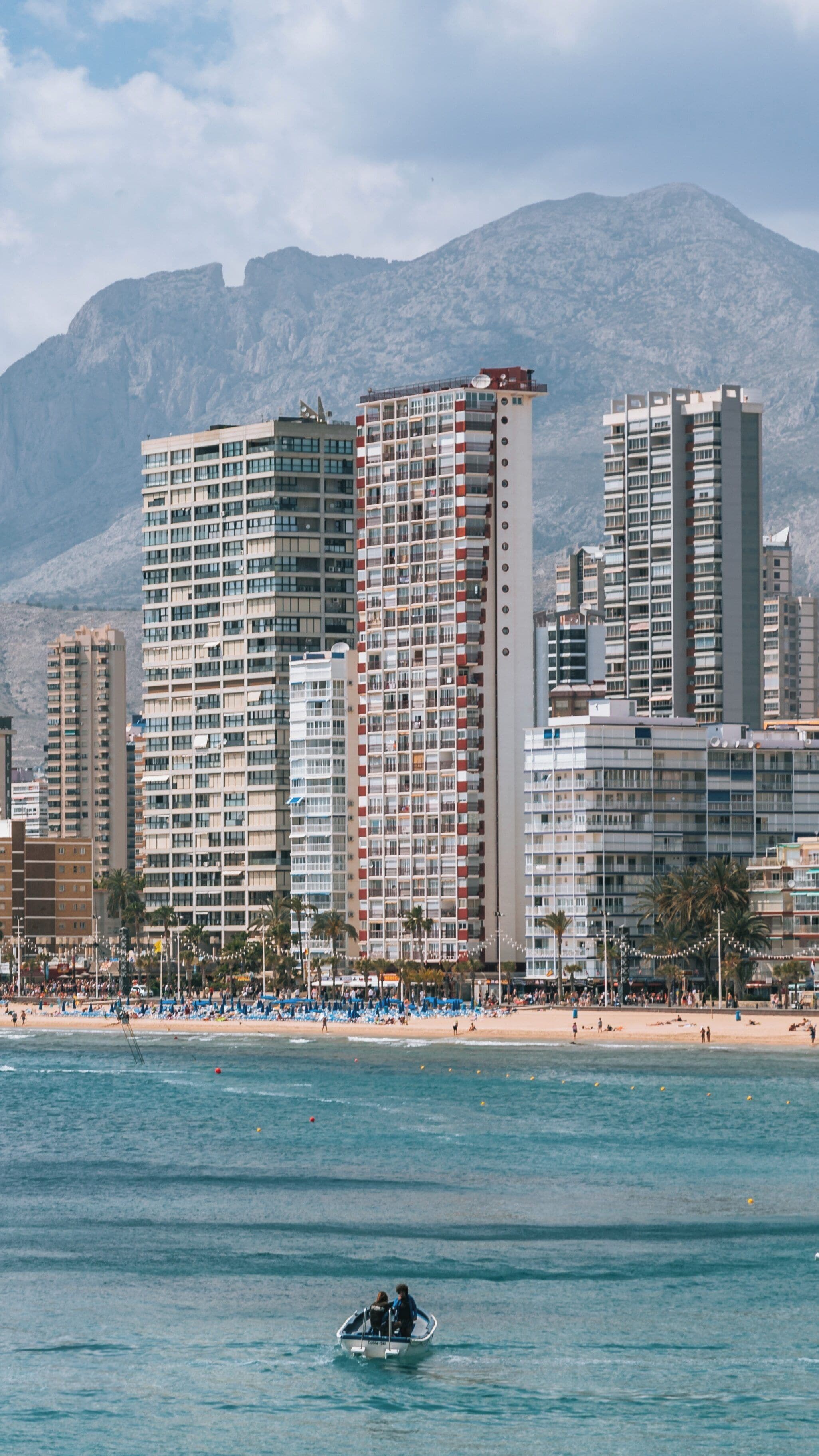 Vibrant waters of Llevant Beach in Benidorm Centro with stunning mountain backdrop showcasing urban life and leisure activities