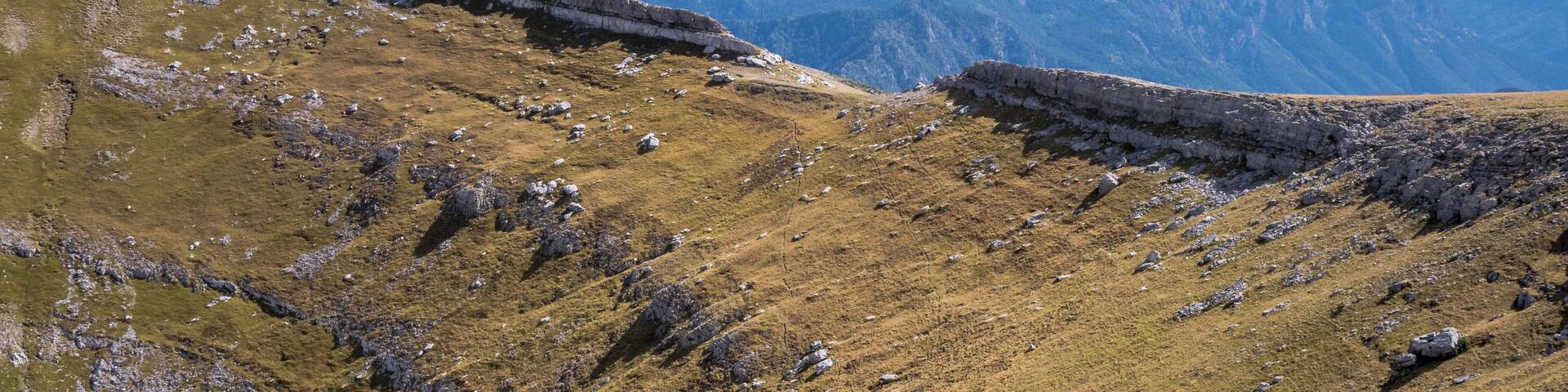 A mountainous landscape with rocky terrain and grassy slopes.