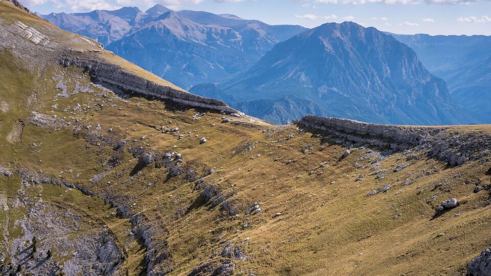 A mountainous landscape with rocky terrain and grassy slopes.