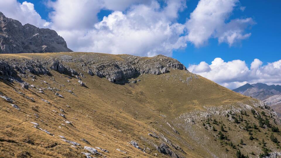 A mountainous landscape with rocky terrain and sparse vegetation.