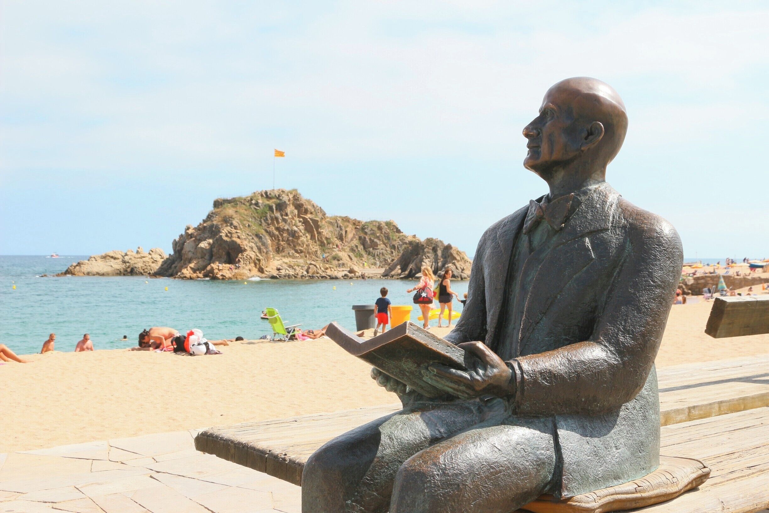 Sitting bronze man on the seafront of Blanes in Spain.