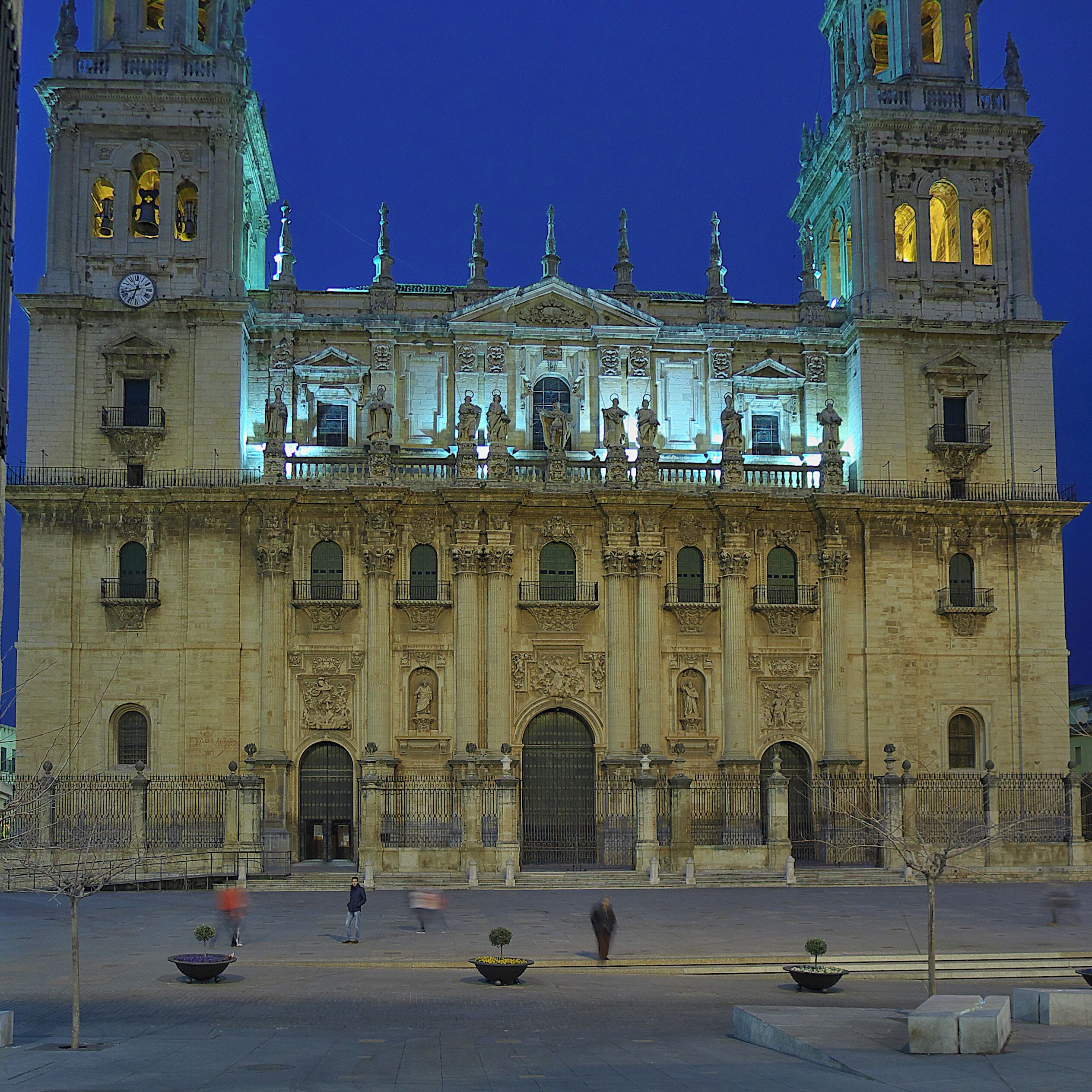 A historic cathedral with two bell towers, ornate statues, and a clock.