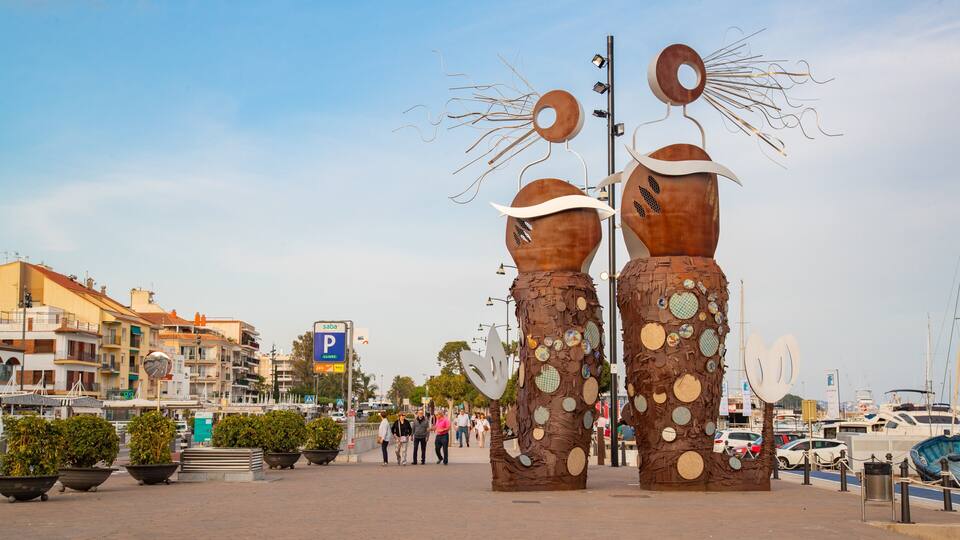 A sculpture of two figures with circular patterns, a parking sign, and a marina with boats.