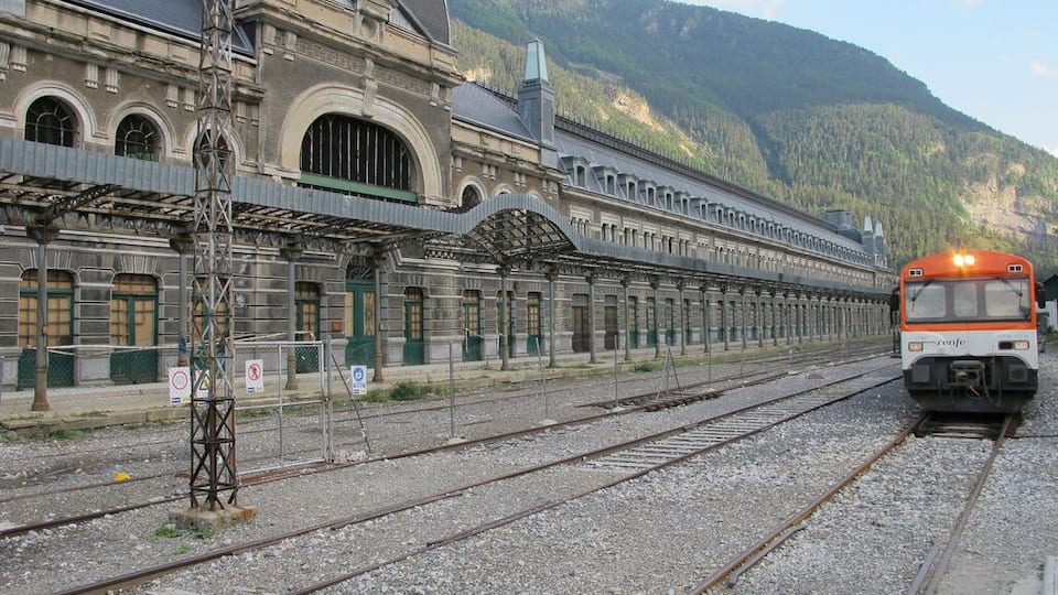 A train station with multiple tracks and a train approaching.