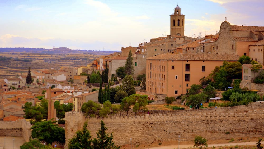 A historic town with a prominent church tower, cobblestone streets, and surrounding greenery.