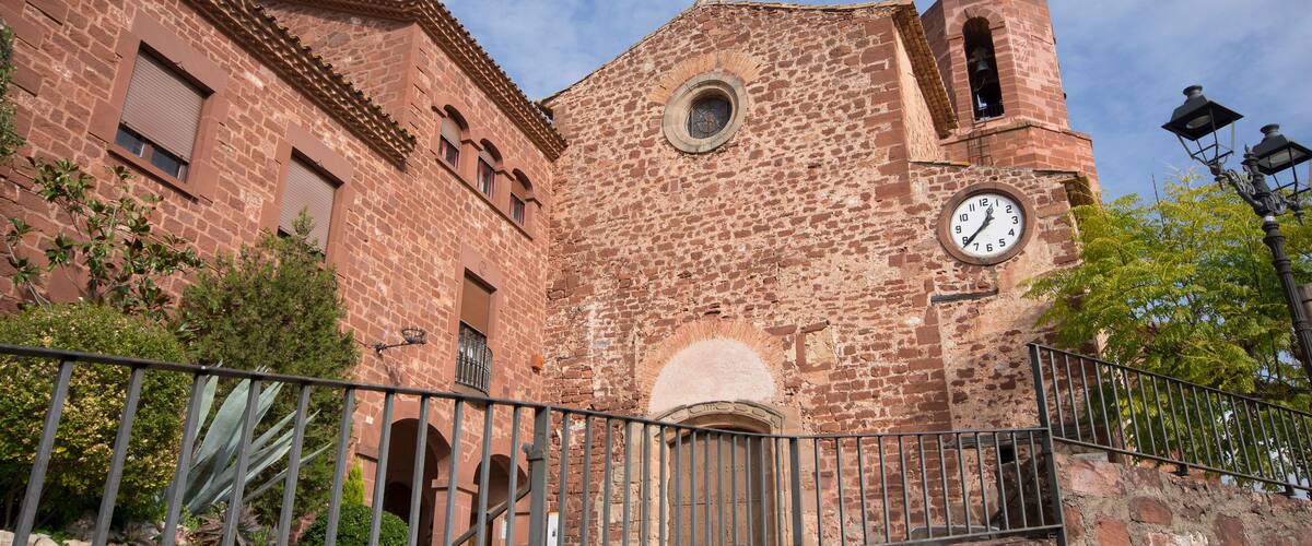 A historic brick building with a clock tower and a round window.