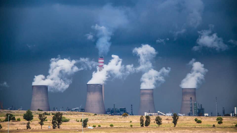 A nuclear power plant with four cooling towers emitting steam.