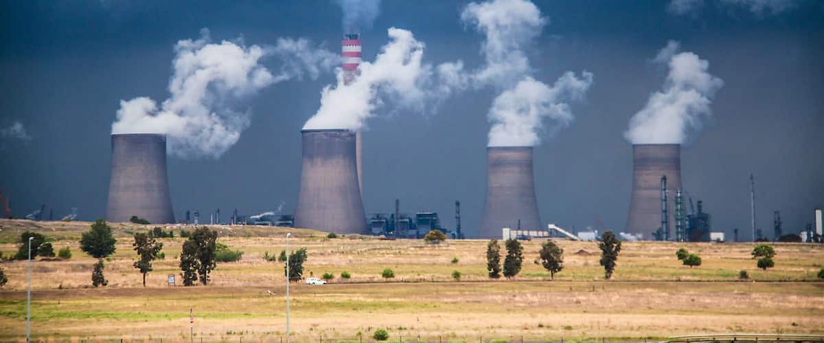 A nuclear power plant with four cooling towers emitting steam.