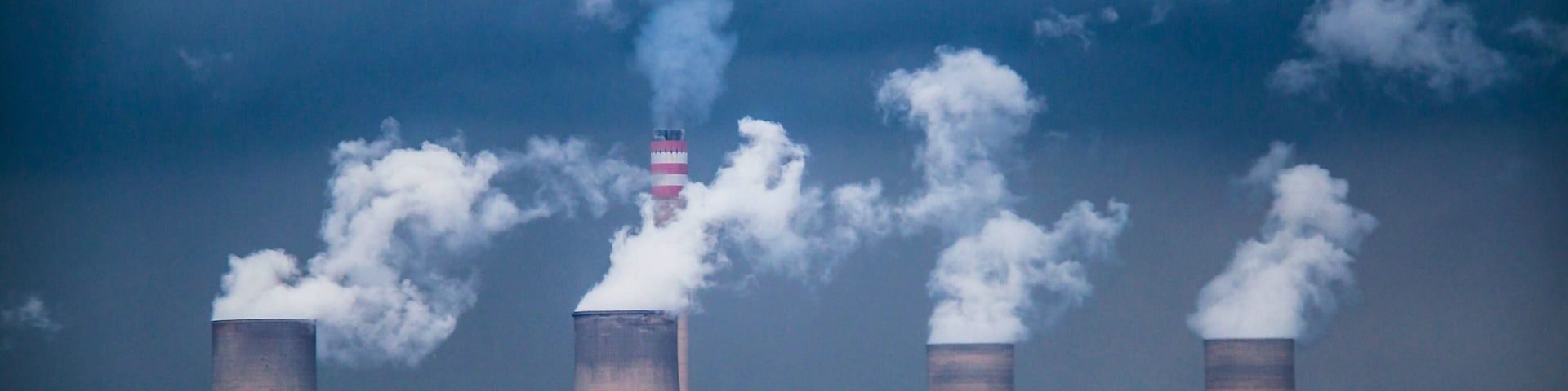 A nuclear power plant with four cooling towers emitting steam.