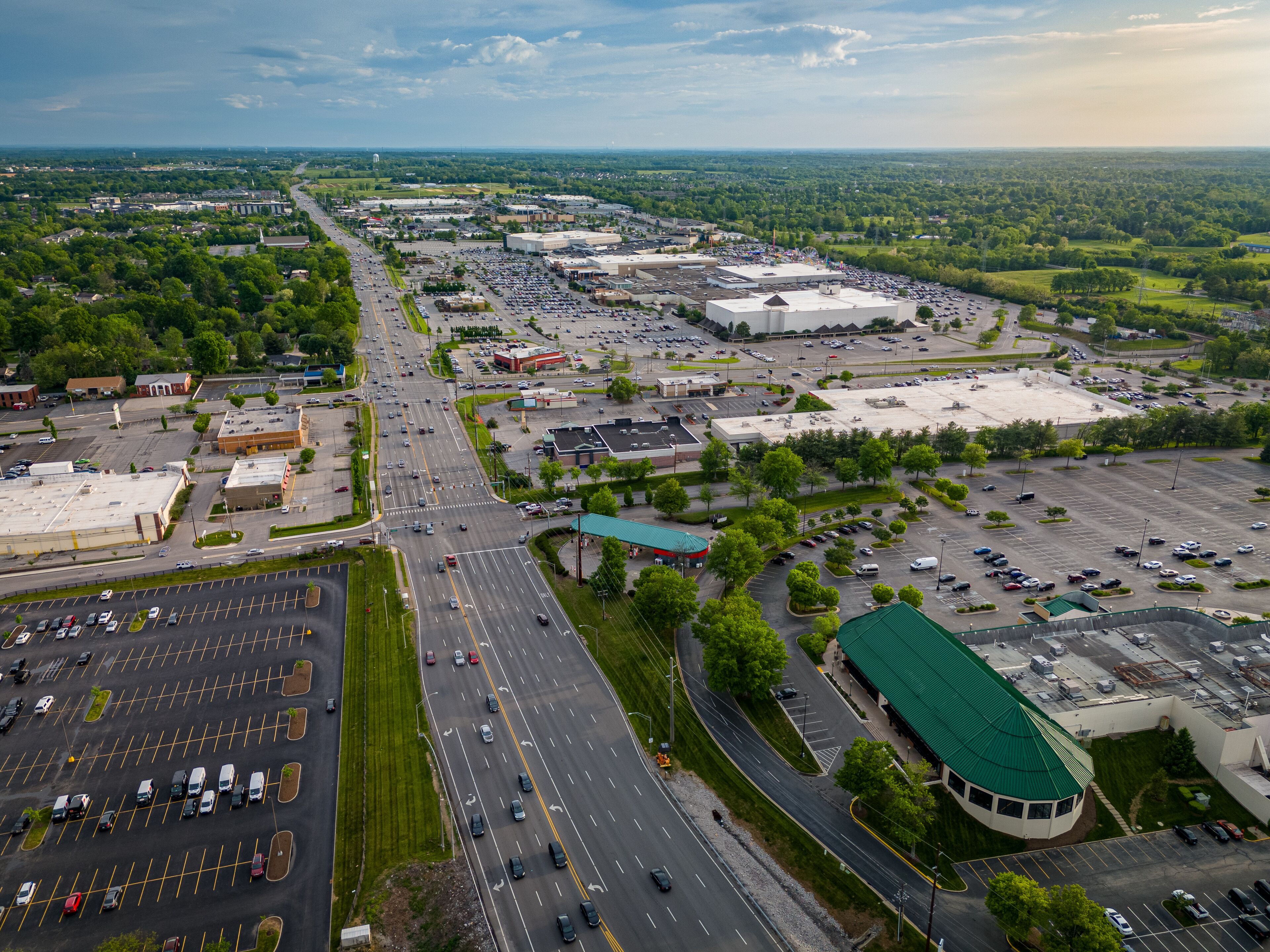 An overhead perspective showcases Fayette Mall located on Nicholasville Road in Lexington, Kentucky, with its adjacent parking lots. The Lexington Green shopping complex dominates the foreground.