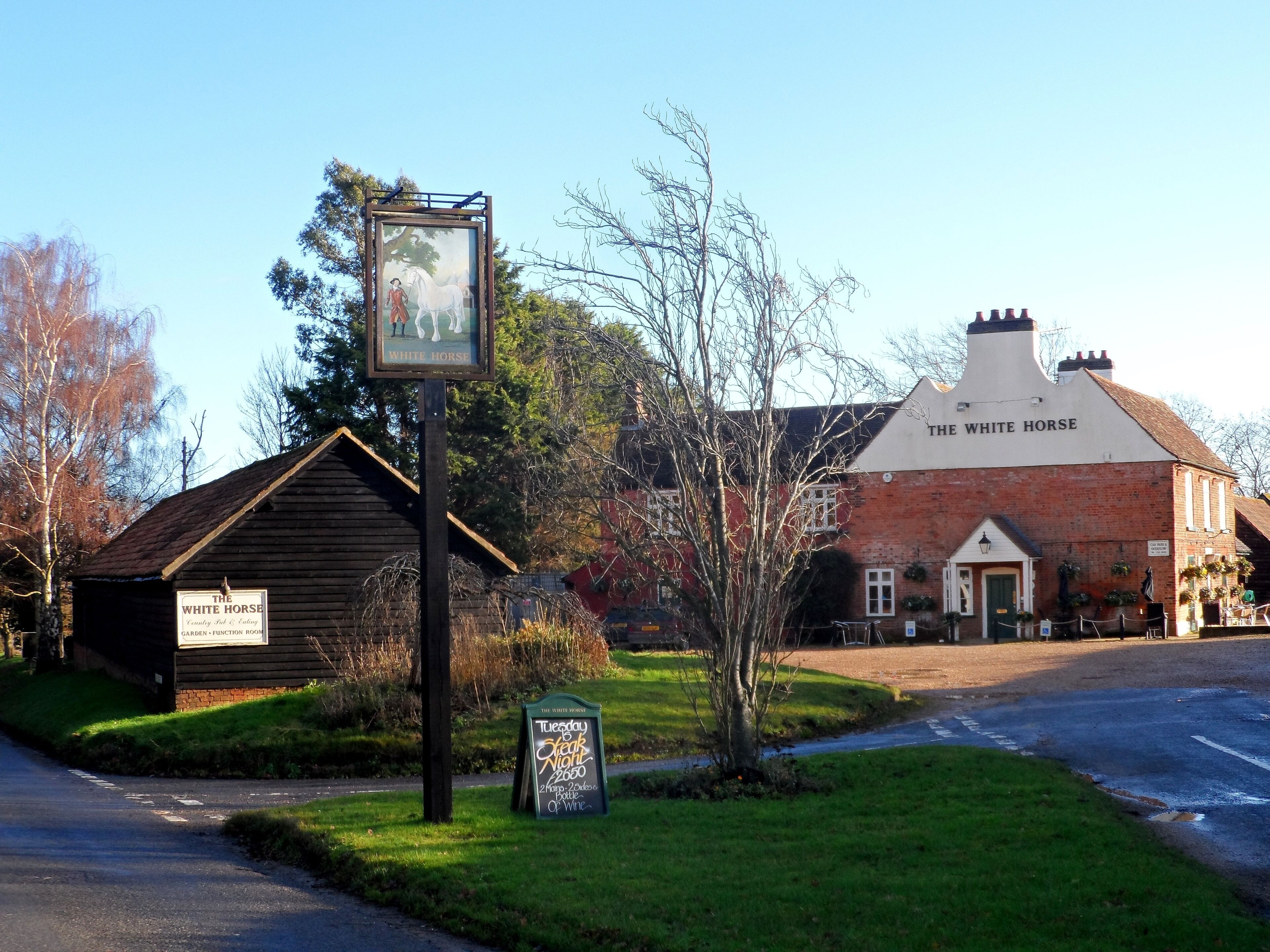 A pub named The White Horse with a signboard and a smaller building labeled as Garden - Function Room.