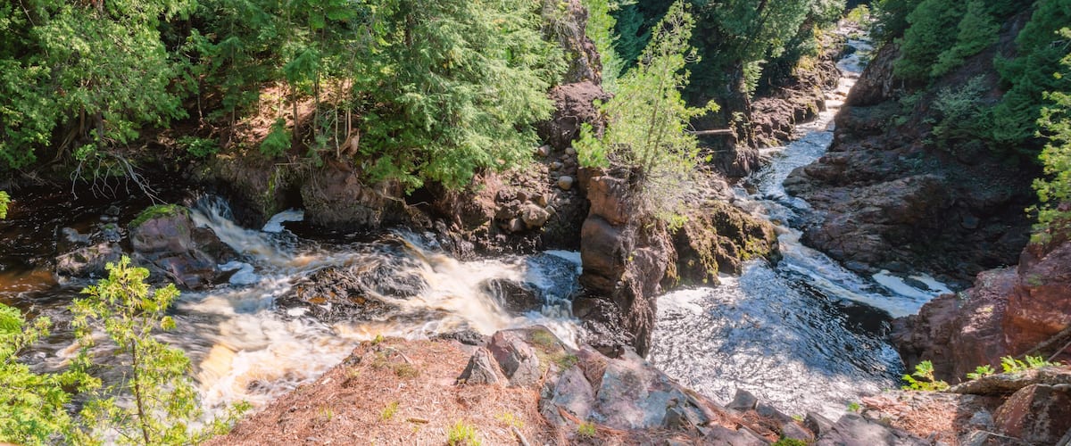 A river flowing through a rocky canyon surrounded by dense forest.