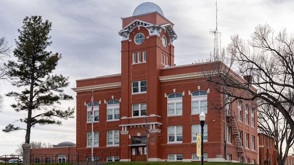 A red brick building with a clock tower and a dome.