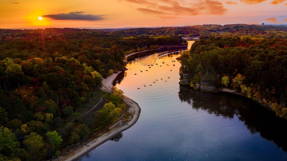 A river winding through a forest at sunset.