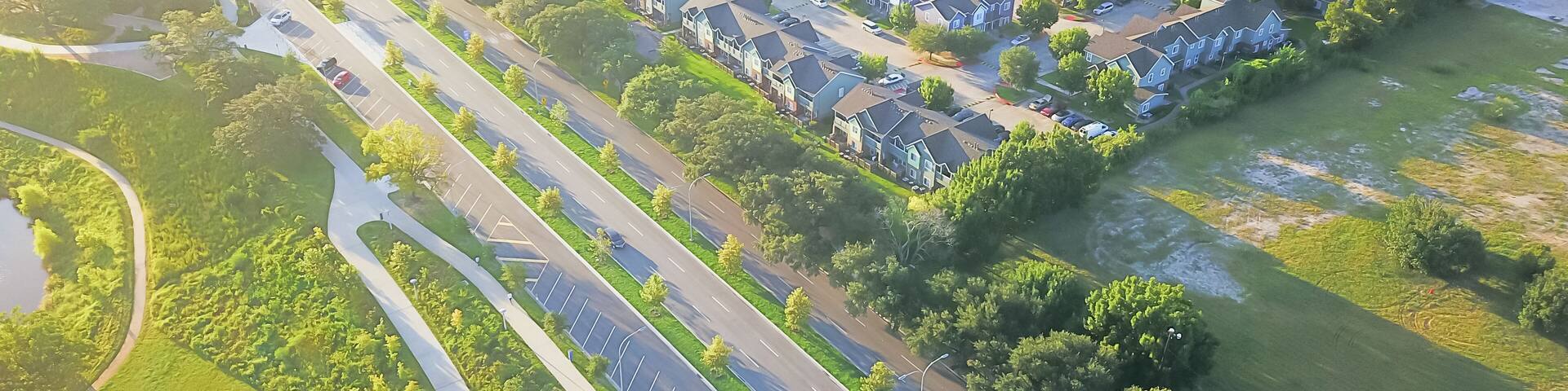 Aerial view Fourth Ward district west of downtown Houston, Texas, USA. Row of apartment complexes, office buildings, restaurants, parking lots, church bordered by Allen Parkway and Buffalo Bayou River