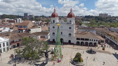 Una iglesia histórica con dos cúpulas, una plaza con una fuente y edificios circundantes.