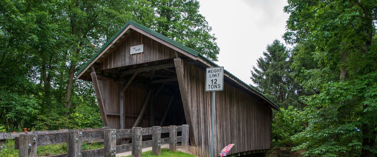 A covered bridge with a 'Weight Limit 12 Tons' sign.