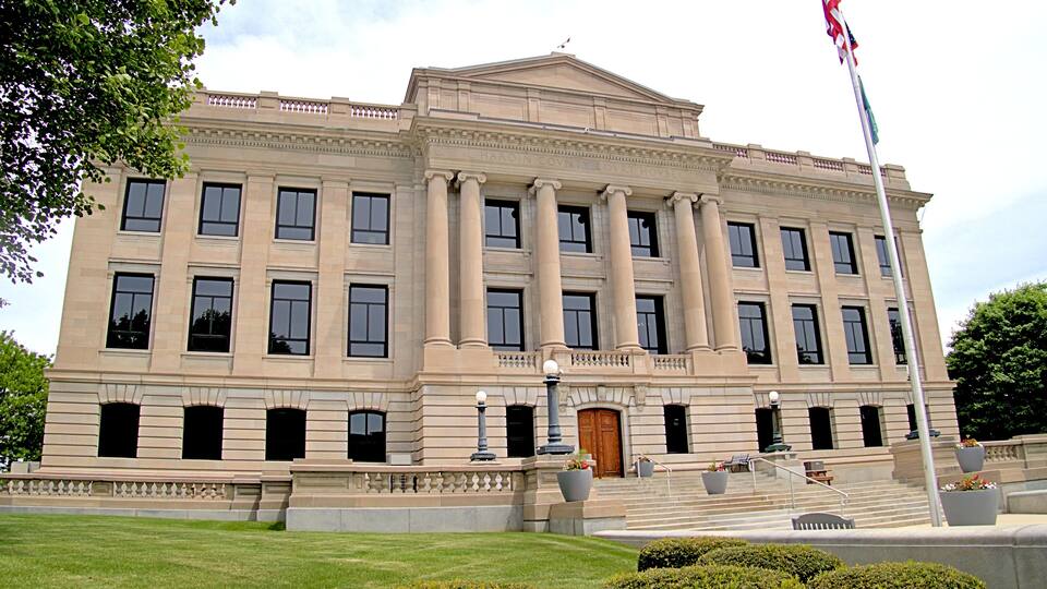 A large, classical building with columns and a flagpole.